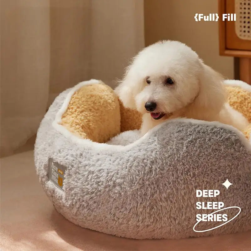Ein flauschiger weißer Hund ruht in einem grauen Plüschkätzchennestbett mit gelbem Bettzeug.