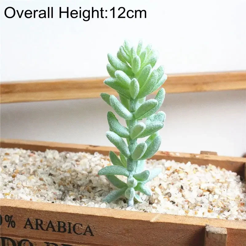 A small, light green flocked artificial succulent plant is displayed in a wooden box filled with white gravel.