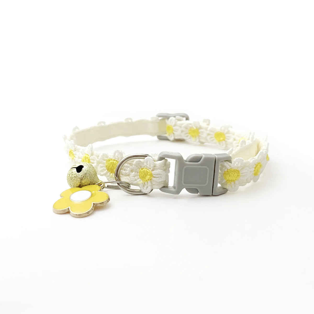 A white lace flower cat collar with a silver buckle and a yellow flower bell.