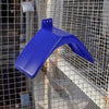Un soporte de percha de paloma y paloma de plástico azul brillante contra un fondo de malla de alambre.