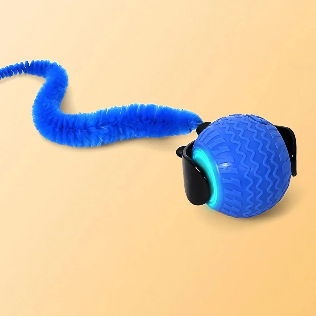 A bright blue, fuzzy pet ball toy with a long tail is shown against a light background.