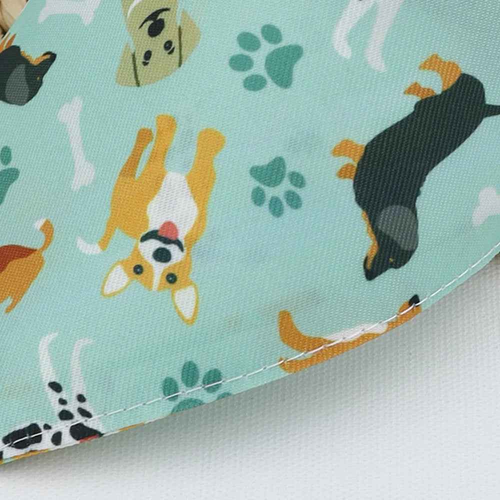 A light teal bandana featuring a cartoon print of a dog's face and paw prints.