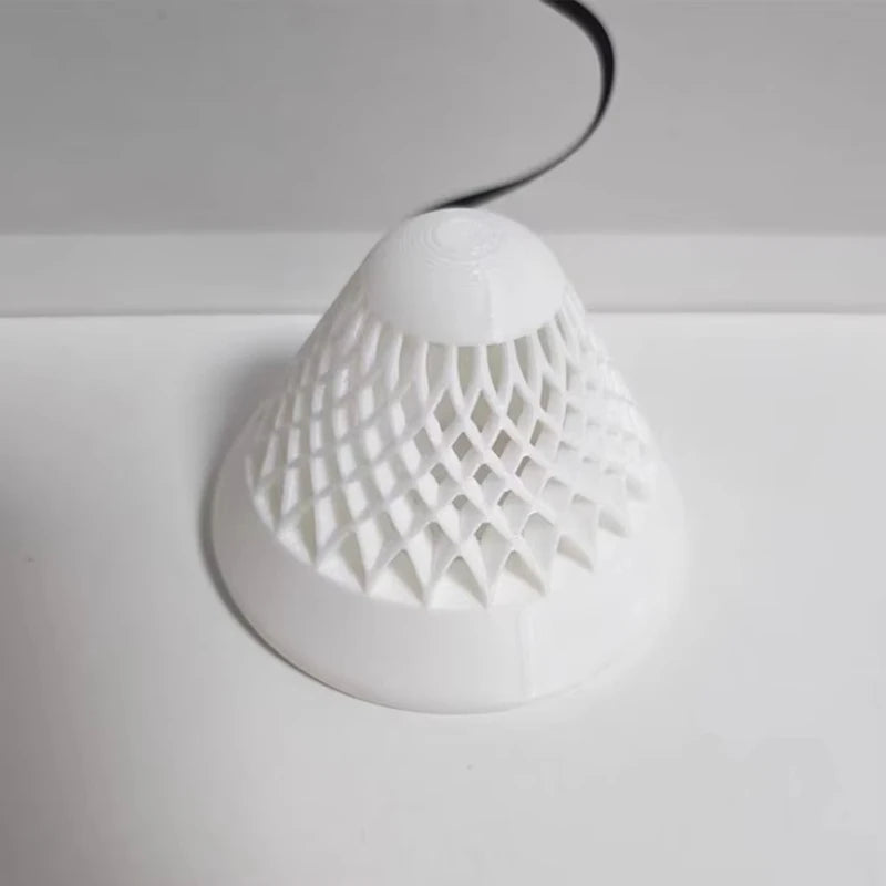A white floating aquarium plant pot with a perforated dome and a black wire extending from the top.