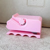 A pink handheld cardboard strip cutter tool with a pink plastic body and a pink cutting blade.