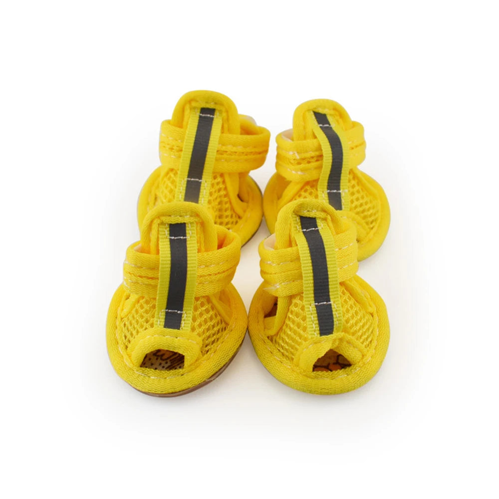 A set of four yellow breathable summer dog shoes with black straps and mesh material.