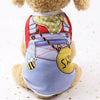 Un chien en peluche portant un gilet à thème d'été avec un motif de train et d'abeille.