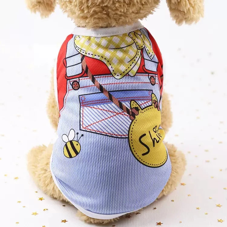 Un chien en peluche portant un gilet à thème d'été avec un motif de train et d'abeille.