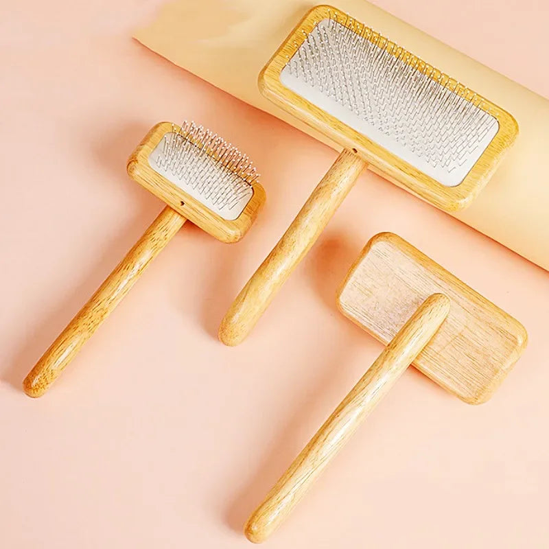 A set of wooden pet grooming brushes, including a wide-toothed brush and a paddle brush, displayed on a light pink background