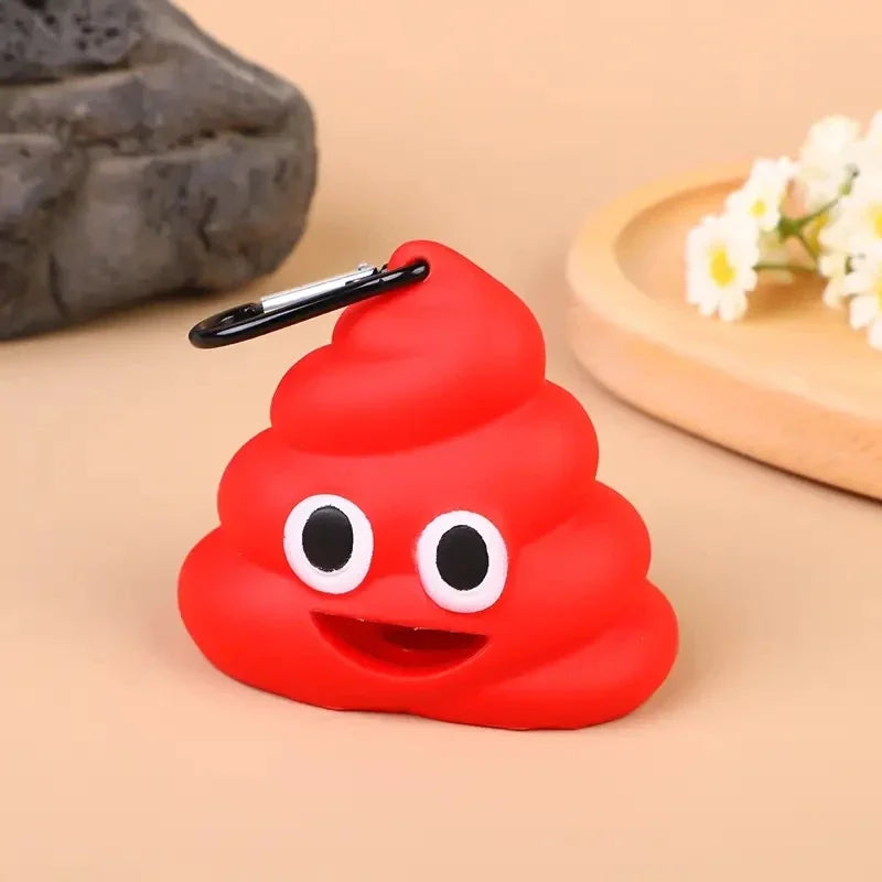A bright red silicone dispenser shaped like a smiling face with black eyes and a clip, resting on a light wooden surface.