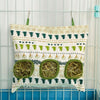 A fabric bag with a patterned design used as a multi-hole hay feeder for small animals.
