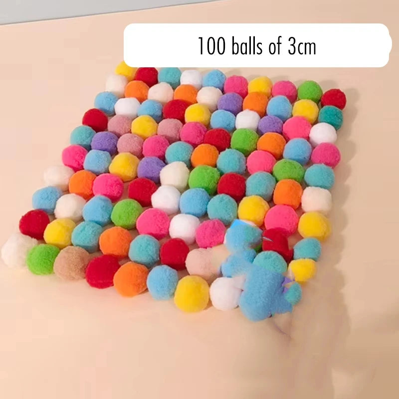 A grid of 100 colorful plush balls in various shades of pink, yellow, green, and blue.
