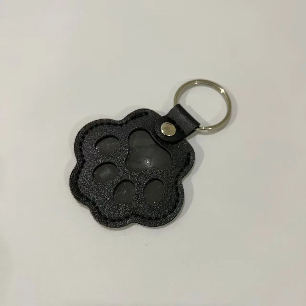 Black leather pet fur keepsake keychain charm with a silver ring.