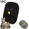 A black reusable pet grooming glove with a yellow finger tip shown next to a kitten.