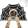 A black mat with a white spider web design features a bowl of pet food and two cat paws.