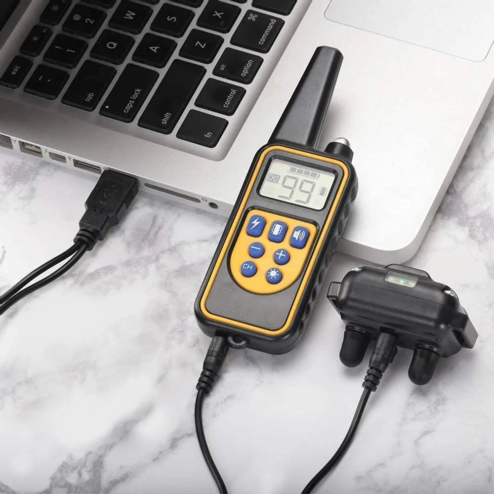 A handheld remote control dog training collar with a digital display showing 99% battery life and a black charging cable.