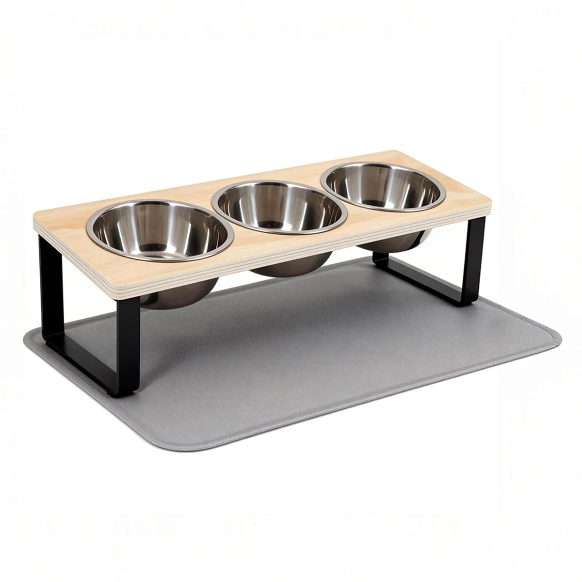 A wooden elevated cat bowl stand with three stainless steel bowls resting on a gray feeding mat.