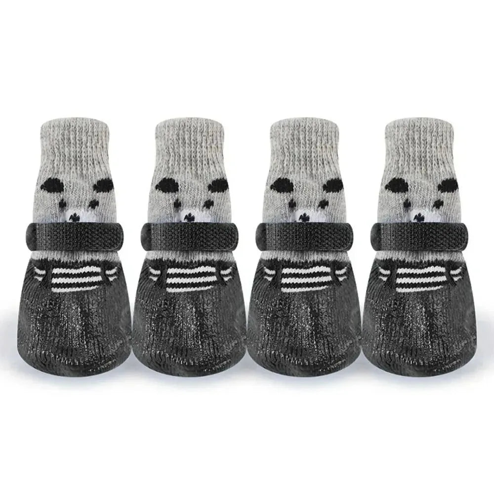 Five pairs of grey and black non-slip dog socks with embroidered faces displayed side by side