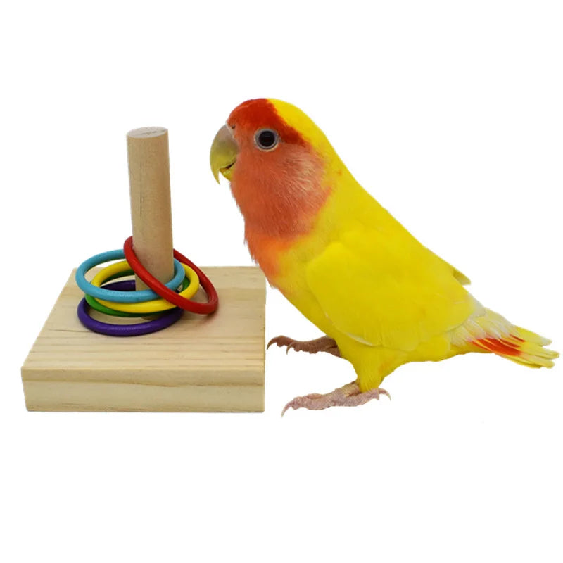A yellow and orange bird toy is perched next to a wooden dowel with colorful stacking rings.