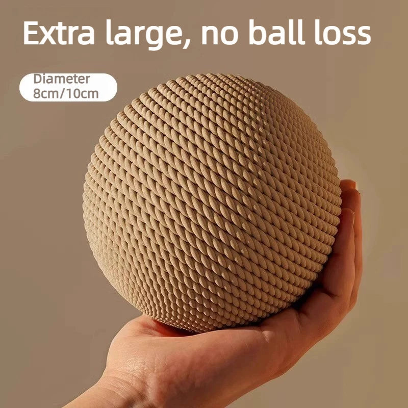 A hand holds a large, textured natural sisal cat toy ball with a rattle.