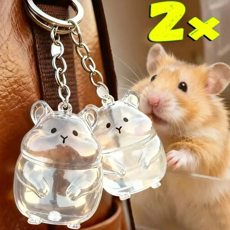 A small orange hamster is looking at a clear glass figurine of a hamster, which is also a keychain.