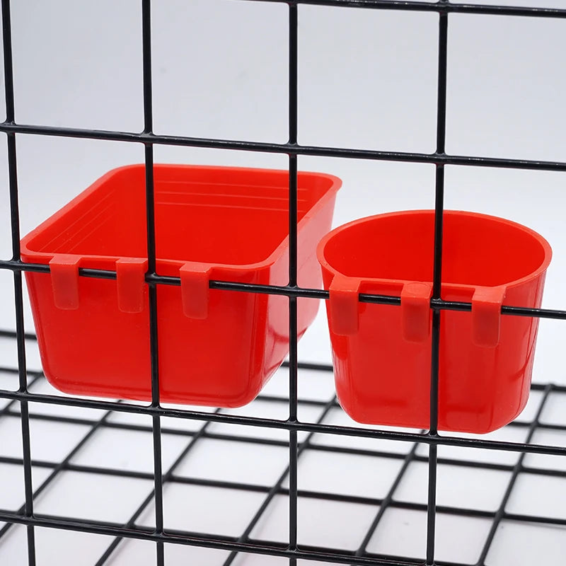 Two bright red plastic bowls are visible through a black wire mesh grid.