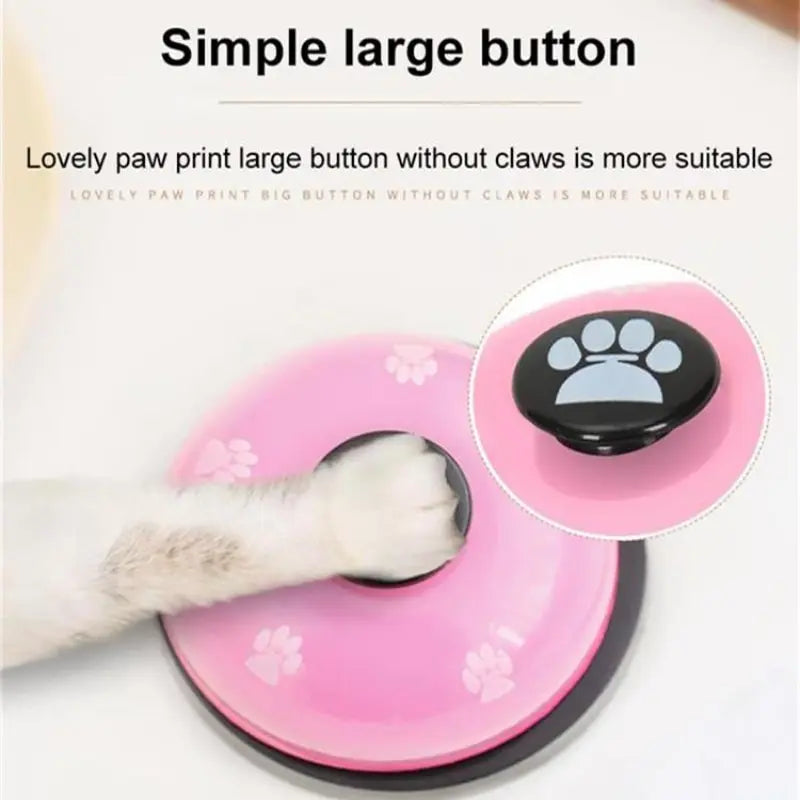 A pink silicone button with a black paw print is shown next to a white paw, demonstrating a large button for pet training.