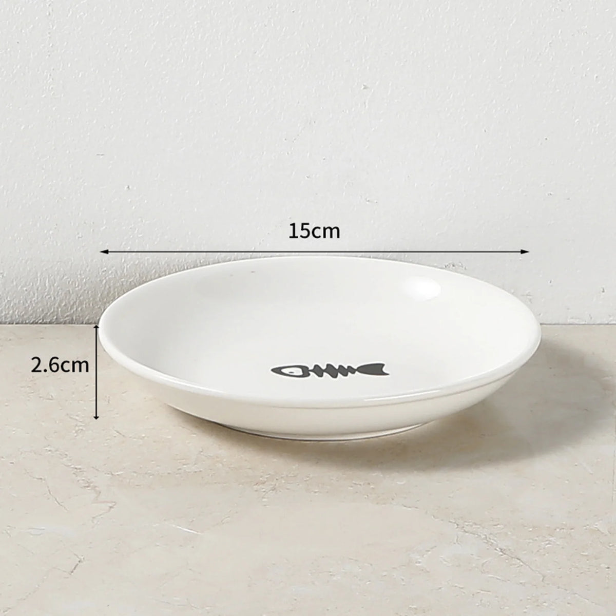 Weiße Keramikschale für Haustiere mit erhabenem Fischdesign, auf einer hellen Oberfläche.