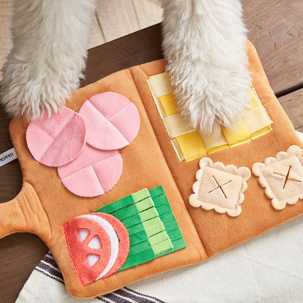 An interactive snuffle mat for dogs featuring soft fur paws and fabric toys like watermelon slices and textured shapes.