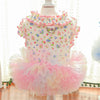 A pink floral vest for dogs and cats displayed on a mannequin.