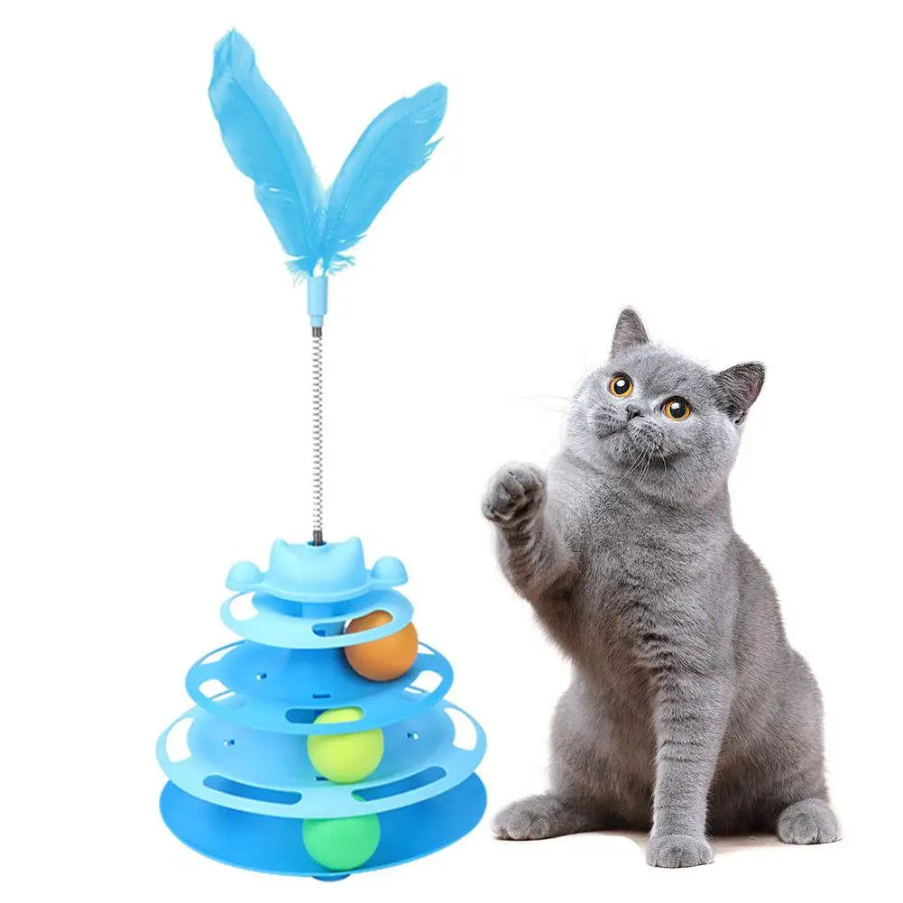 A gray cat is sitting next to an interactive rotating feather toy tower made of blue plastic.