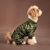 A light brown poodle wearing a green leopard print jumpsuit.