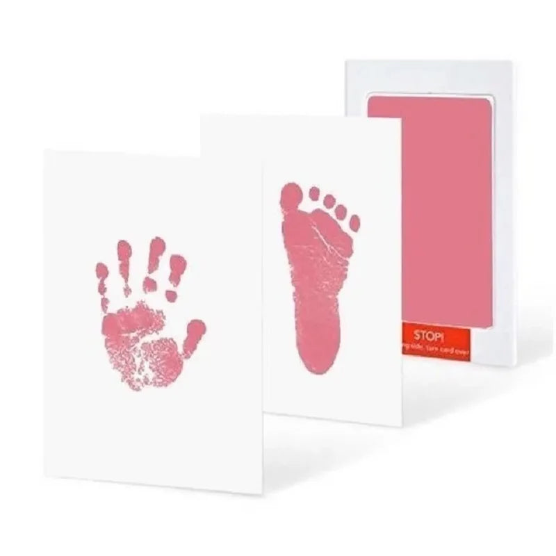 Une carte blanche avec une empreinte de main et de pied rose, à côté d'une carte rose avec un découpe rectangulaire.
