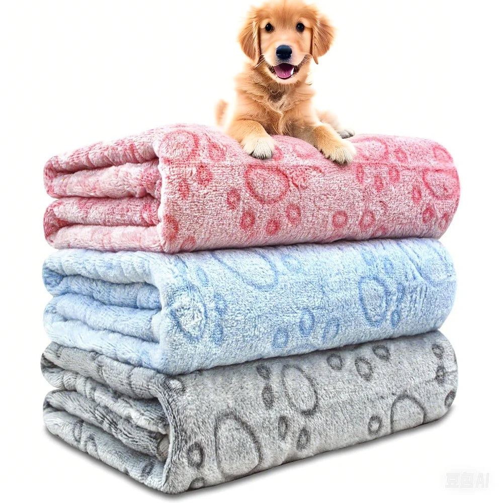A golden retriever puppy is resting on a stack of three ultra-soft pet blankets in pink, light blue, and gray.
