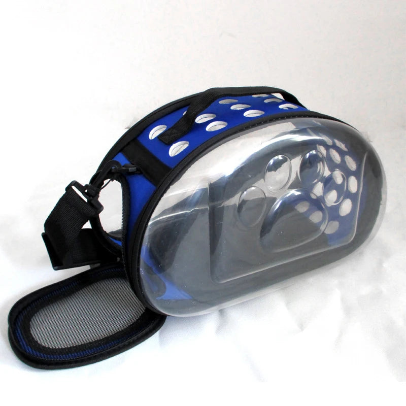 Transparent foldable pet travel carrier with a blue and white polka dot pattern and black shoulder strap