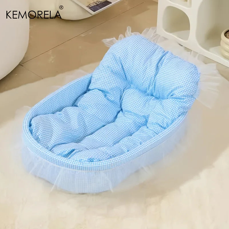 Light blue quilted pet bed mat with sheer fabric trim resting on a white surface.