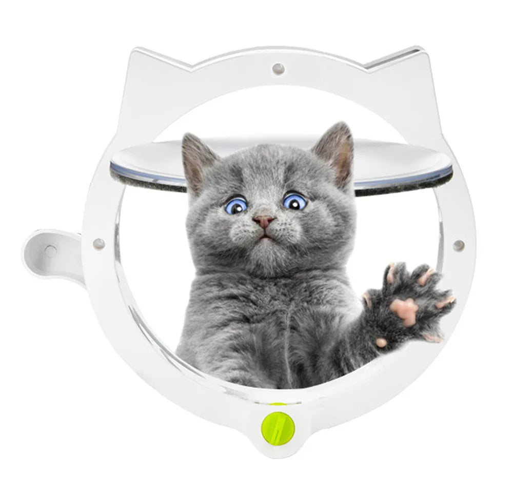 A fluffy gray kitten is looking out of a white, oval-shaped pet door with a clear viewing window.