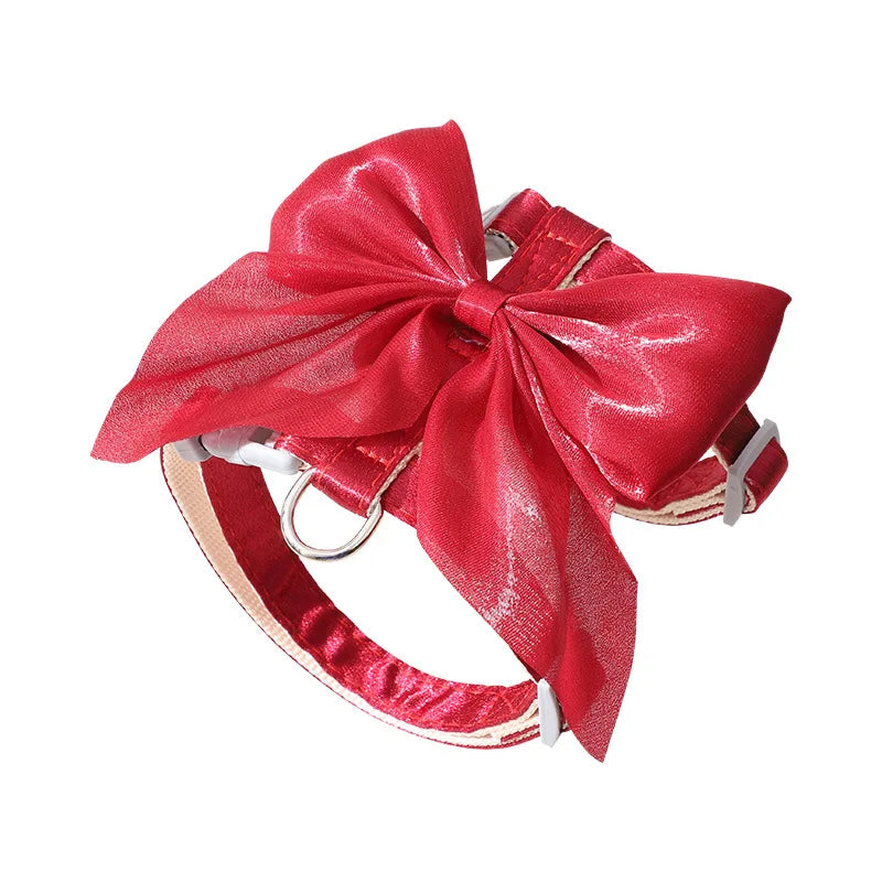 A red satin bow attached to an adjustable cat harness and leash set.