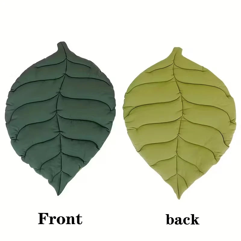 Front and back views of a reversible leaf-print pet cushion with a non-slip base in olive green and lime green colors.