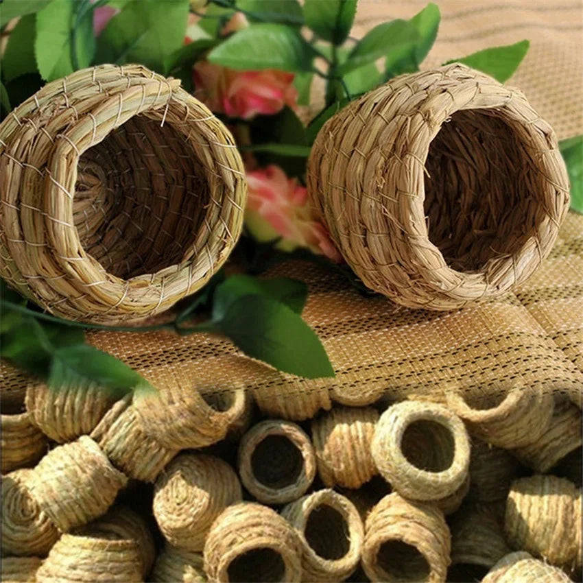 Handwoven straw bird nests for small birds resting on burlap fabric.
