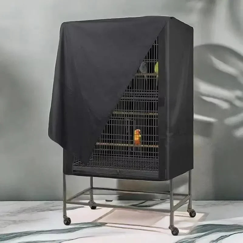 A black Oxford cloth bird cage cover is shown draped over a wire cage, used as a dustproof and light-blocking shade.
