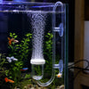 A clear glass aquarium setup showing an aquarium CO2 diffuser with a bubble counter and control valve, surrounded by aquatic 