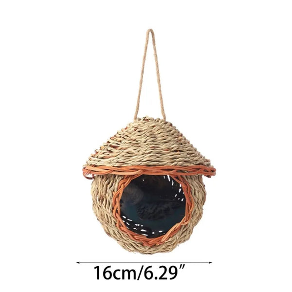 A natural grass hanging bird nest with an entrance, suspended by twine.