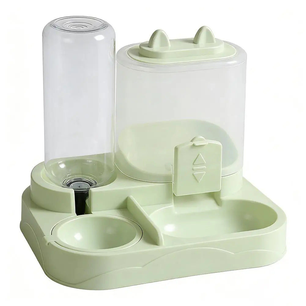 A light green gravity-fed pet food dispenser with a clear cylinder and a separate water bowl for cats and small dogs.