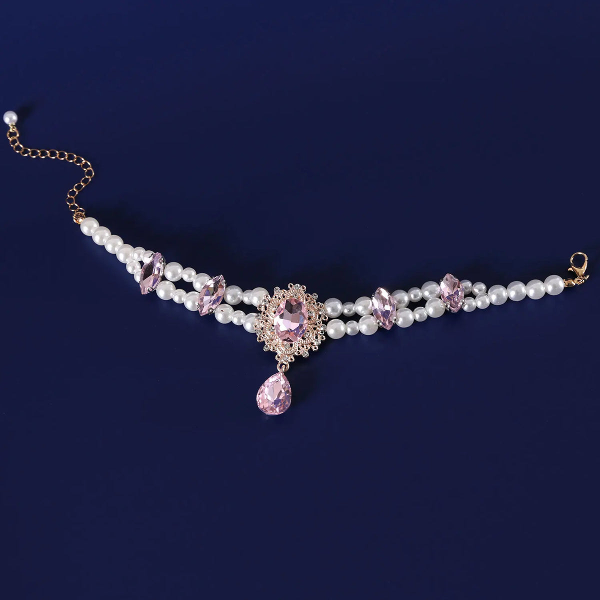 A delicate pearl and pink gemstone collar for pets, featuring a chain and decorative elements.