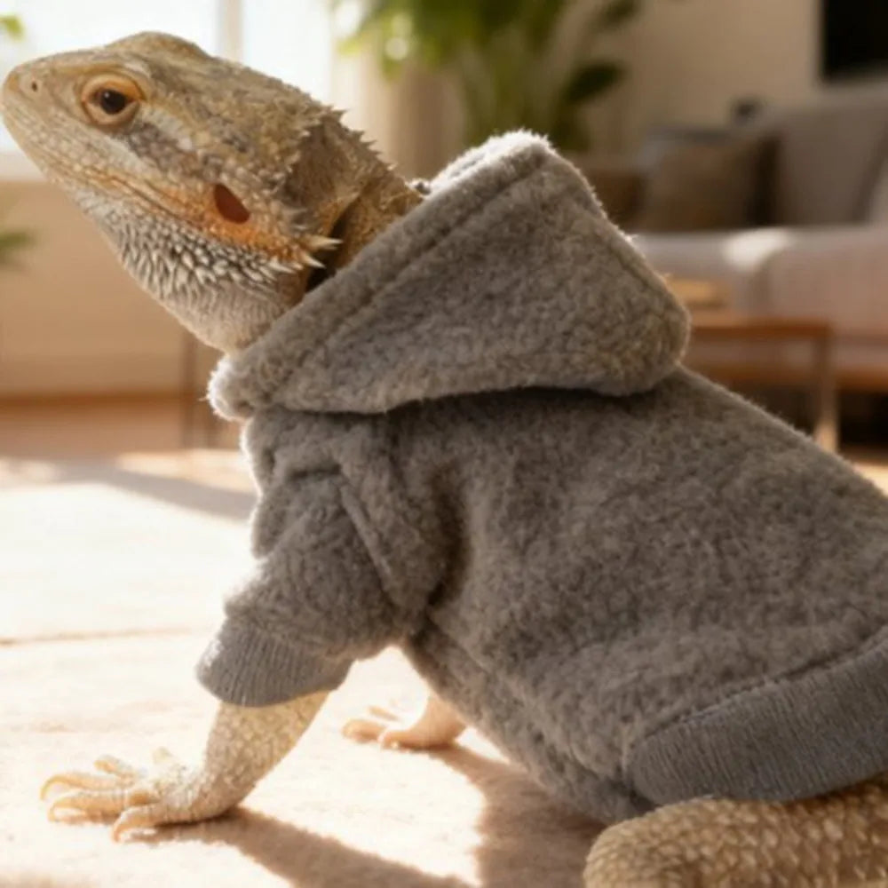 A bearded dragon costume resembling a fuzzy gray hoodie, lying on a light-colored surface.