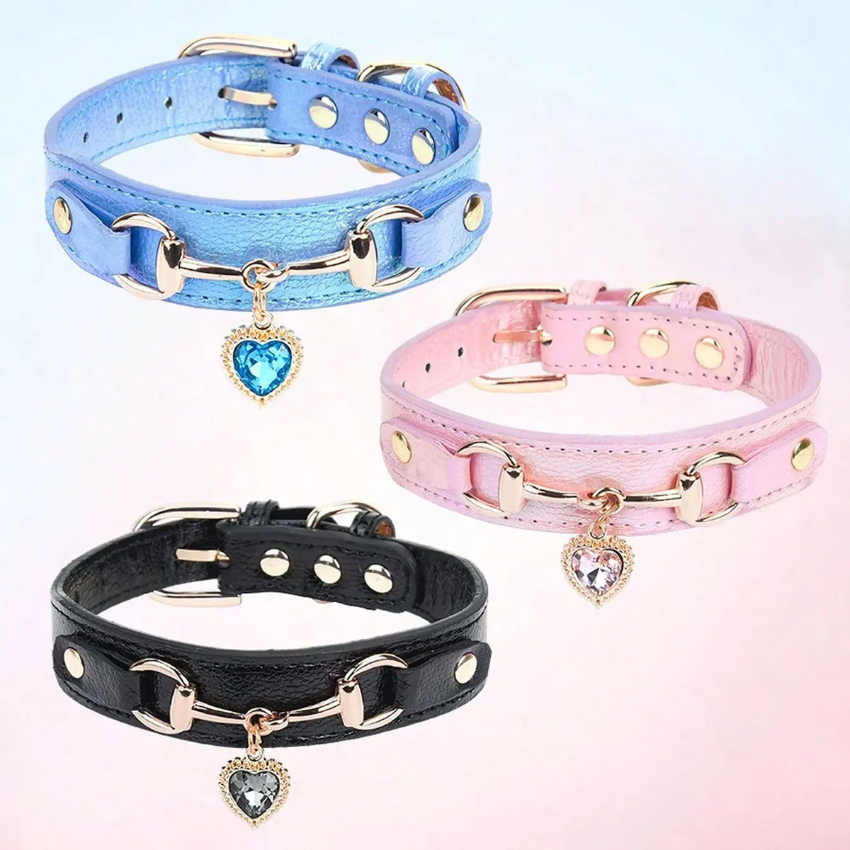 Three gemstone-embellished PU leather dog collars in blue, pink, and black with gold hardware.