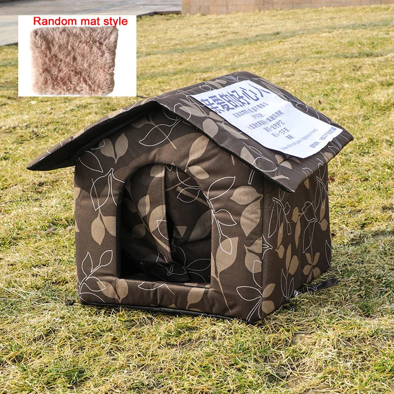 Abri pour chat extérieur marron et imperméable avec toit incliné et motif de feuilles, posé sur de l'herbe verte.