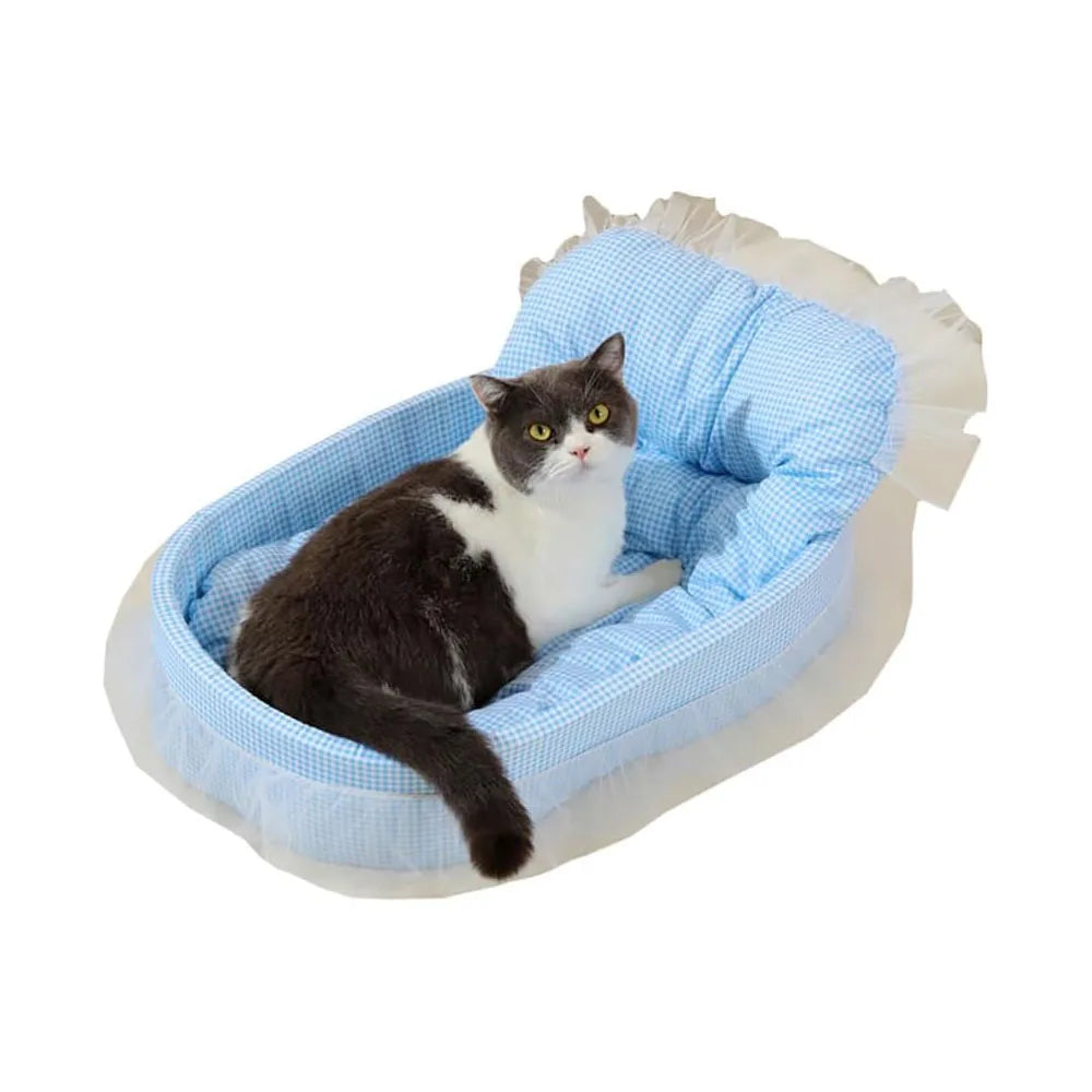 A black and white cat is relaxing in a light blue lace-trimmed plush pet sofa bed.