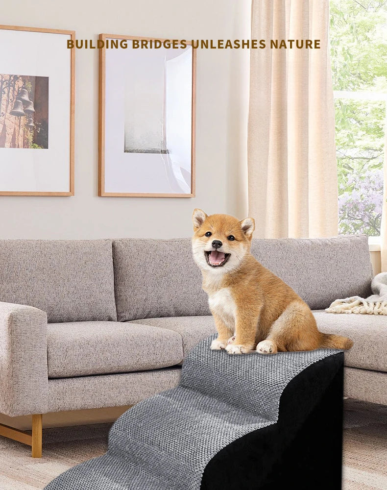 A fluffy orange dog is sitting on a gray memory foam pet ramp indoors next to a sofa.