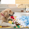 A golden retriever lies on a yellow blanket with various toys and fabric pieces for dog sniffing training.